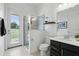 Bright bathroom featuring glass-enclosed shower, modern vanity, and access door to backyard at 2118 Whiting Trl, Orlando, FL 32820