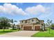 Attractive home with lush landscaping, three car garage and brick paved driveway on a sunny day at 2118 Whiting Trl, Orlando, FL 32820