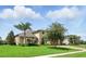 Elegant home featuring a three-car garage, lush lawn and verdant landscaping at 2118 Whiting Trl, Orlando, FL 32820