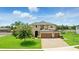 Elegant two-story home featuring a three-car garage, lush lawn and verdant landscaping at 2118 Whiting Trl, Orlando, FL 32820