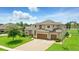 Charming two-story home with lush green lawn, and brick driveway leading to the attached garage at 2118 Whiting Trl, Orlando, FL 32820