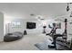 Spacious home gym with ample natural light, a large television, and a variety of exercise equipment at 2118 Whiting Trl, Orlando, FL 32820