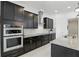 Modern kitchen features sleek black cabinets, stainless steel appliances, and granite countertops at 2118 Whiting Trl, Orlando, FL 32820