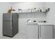 Functional laundry room featuring a front-load washer and dryer, a stainless steel fridge, and ample storage at 2118 Whiting Trl, Orlando, FL 32820