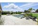 Backyard with a modern pool, lounge chairs, umbrella, lush landscaping, and privacy fence at 2118 Whiting Trl, Orlando, FL 32820
