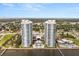 Breathtaking aerial view of waterfront condominiums featuring lush landscaping, pools, and waterfront access at 241 Riverside Dr # 902, Holly Hill, FL 32117