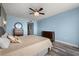 Bedroom with blue walls, hardwood floors, ceiling fan, and water views at 241 Riverside Dr # 902, Holly Hill, FL 32117