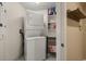 Convenient laundry room featuring a stacked washer and dryer, along with shelving for storage and organization at 241 Riverside Dr # 902, Holly Hill, FL 32117