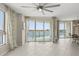 Bright living room with white tile floors, ceiling fan, and sliding doors to the water view balcony at 241 Riverside Dr # 902, Holly Hill, FL 32117