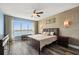 Bedroom with hardwood floors, ceiling fan, accent wall, and window to water views at 241 Riverside Dr # 902, Holly Hill, FL 32117
