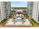 Stunning aerial view showcasing the pool amenities nestled between two high-rise condominium towers at 241 Riverside Dr # 902, Holly Hill, FL 32117