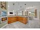 Spacious kitchen with wooden cabinets, white tile floors, and views of the dining area at 2523 Madron Ct, Orlando, FL 32806