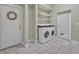 Functional laundry room features tile flooring, stacked shelves, washer and dryer, and an exterior door at 2523 Madron Ct, Orlando, FL 32806