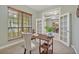 Bright home office features a wooden desk, a neutral chair, a window and an entry to the dining room at 2523 Madron Ct, Orlando, FL 32806