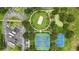 Overhead view of park featuring a sand volleyball court, mini-golf, basketball, and tennis courts surrounded by lush trees at 2531 Maneshaw Ln, Kissimmee, FL 34747