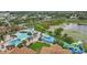 An aerial view of a community pool, water park, and serene lake, creating a picturesque and inviting atmosphere at 2531 Maneshaw Ln, Kissimmee, FL 34747
