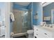 Bathroom with glass-enclosed shower featuring gray tile and a modern white vanity at 2531 Maneshaw Ln, Kissimmee, FL 34747