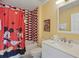 Bathroom features a Mickey Mouse shower curtain and red/black brick tiling at 2531 Maneshaw Ln, Kissimmee, FL 34747