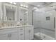 Bright bathroom features a glass-enclosed shower and double sinks with vanity at 2531 Maneshaw Ln, Kissimmee, FL 34747