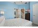 Bright bedroom features blue walls, white trim, and a TV mounted on a dresser at 2531 Maneshaw Ln, Kissimmee, FL 34747