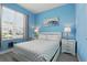 Bright bedroom with light-blue walls, a comfortable bed, and windows providing natural light, creating a peaceful retreat at 2531 Maneshaw Ln, Kissimmee, FL 34747