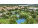 Aerial view of community amenities including tennis courts, basketball court, lush landscaping, and parking at 2531 Maneshaw Ln, Kissimmee, FL 34747