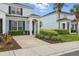 Townhouse exterior featuring a driveway, manicured shrubs, and covered entrance at 2531 Maneshaw Ln, Kissimmee, FL 34747