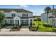 Light blue two-story townhouse with a manicured garden and dark shutters at 2531 Maneshaw Ln, Kissimmee, FL 34747