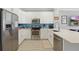 Contemporary kitchen with white cabinets, quartz counters, stainless steel appliances, and a stylish blue tile backsplash at 2531 Maneshaw Ln, Kissimmee, FL 34747