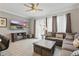 Well-lit living room with large windows, comfortable seating, and a television, creating a cozy and inviting atmosphere at 2531 Maneshaw Ln, Kissimmee, FL 34747