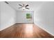 Bright bedroom with hardwood floors, ceiling fan, and a window offering natural light and backyard views at 2741 Beaver Dr, Deltona, FL 32725