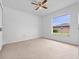 Bright bedroom features neutral carpeting, ceiling fan, and a window with natural light at 2741 Beaver Dr, Deltona, FL 32725
