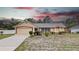 Charming single-story home with well-manicured landscaping and a two-car garage under dramatic sky at 2741 Beaver Dr, Deltona, FL 32725