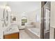 A relaxing bathroom featuring a soaking tub with tile surround and a separate glass shower at 2809 Gulf Winds Ct, Oviedo, FL 32765
