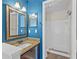 Bathroom with a spacious vanity, decorative mirror and step-in shower with white tiles at 2930 Candela Ct, Apopka, FL 32703