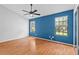 Bright bedroom with hardwood floors, ceiling fan, and two windows with natural light at 2930 Candela Ct, Apopka, FL 32703
