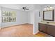 A spacious bedroom with wood floors, a ceiling fan and large window offering lots of light at 2930 Candela Ct, Apopka, FL 32703