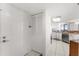 Hallway with tile flooring leading to the kitchen with white cabinetry and stainless steel appliances at 3023 S Atlantic Ave # 2050, Daytona Beach, FL 32118