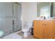 Bathroom with glass-enclosed shower, toilet, vanity and sink with ample lighting at 3065 Yellow Lantana Ln, Kissimmee, FL 34747