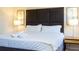 Cozy bedroom featuring a plush king bed with an upholstered headboard and reading lamps at 3065 Yellow Lantana Ln, Kissimmee, FL 34747