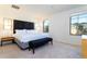 Inviting bedroom with king bed, bench, modern side tables, and ample natural light from windows at 3065 Yellow Lantana Ln, Kissimmee, FL 34747