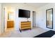 Bright bedroom featuring a sleek dresser, a wall-mounted TV, and an ensuite bathroom entrance at 3065 Yellow Lantana Ln, Kissimmee, FL 34747