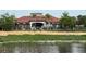 Community clubhouse surrounded by lush landscaping and a pond at 3065 Yellow Lantana Ln, Kissimmee, FL 34747