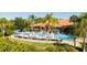 Community pool featuring lounge chairs, umbrellas, and palm trees at 3065 Yellow Lantana Ln, Kissimmee, FL 34747