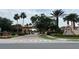 Community entrance with palm trees, lush landscaping, and decorative details at 3065 Yellow Lantana Ln, Kissimmee, FL 34747
