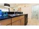 Modern kitchen with granite countertops, stainless steel sink, and black appliances at 3065 Yellow Lantana Ln, Kissimmee, FL 34747