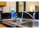 Close up of double sink with granite countertops, modern faucet, and wood cabinetry at 3065 Yellow Lantana Ln, Kissimmee, FL 34747