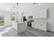 A well-lit kitchen with white cabinets, an island, stainless steel appliances, and modern pendant lighting at 3159 Sw 127Th Lane Rd, Ocala, FL 34473