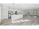 Open concept living room and kitchen with stainless steel appliances, pendant lights, and sleek floors at 3159 Sw 127Th Lane Rd, Ocala, FL 34473