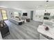 Open concept living space with white kitchen, wood-look flooring, and modern decor at 3159 Sw 127Th Lane Rd, Ocala, FL 34473